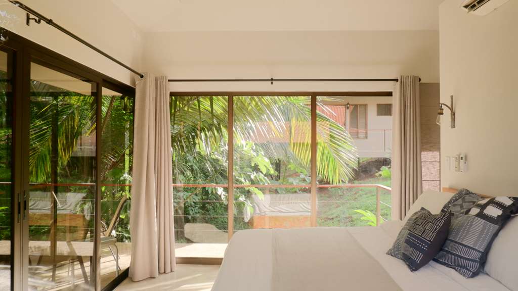 bedroom in a costa rica casita with sliding doors to the jungle